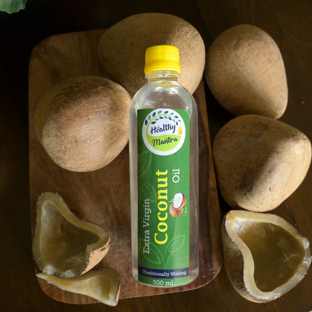 Coconut oil bottle beside a split coconut